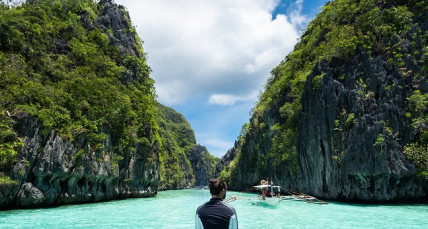 Mann auf Boot auf glasklarem Meer in Thailand