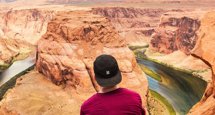 Mann mit Kappe blickt auf die Landschaft des Horseshoe Bend in Arizona, USA