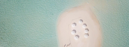 Blick auf einen Strand auf den Malediven mit Sonnenschirmen