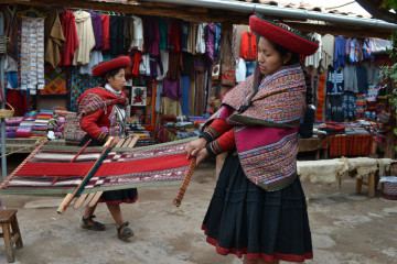 Peruanische Frau beim Weben auf dem Markt in Peru