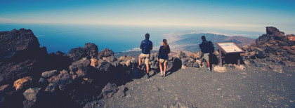 Eine Gruppe Wanderer stehen auf einen Berg und schauen herunter