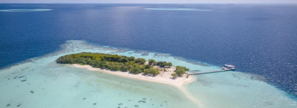 Blick auf eine kleine Insel auf dem Malediven mit einem kleinen steck