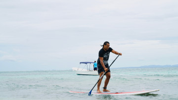 Blick auf einen Surfer auf dem Meer und ein Boot 