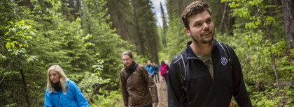Eine Gruppe junger Leute geht in einem Wald in Kanada Spazieren 