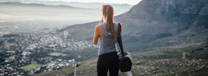 Frau steht auf dem Tafelberg und blickt auf Kapstadt