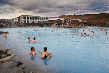 Ein Schwimmbad in Island mit vielen Menschen im Wasser 