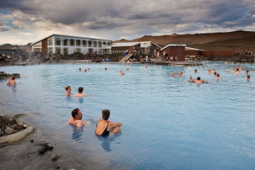 Ein Schwimmbad in Island mit vielen Menschen im Wasser