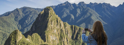Ein Mädchen fotografiert Machu Picchu in Peru