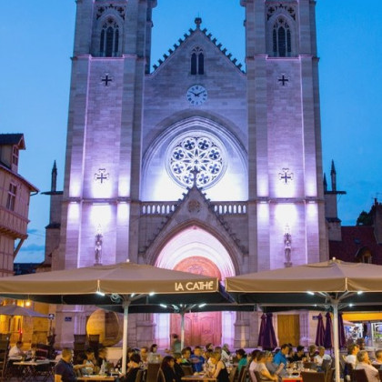 Eine Kirche und vor ihr ein Restaurant mit vielen Menschen