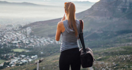 Frau steht auf dem Tafelberg und blickt auf Kapstadt