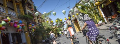 Ein paar Leute Radeln durch eine Stadt in Vietnam 