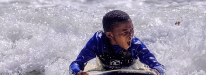 Ein Kind Surft auf dem Wasser 