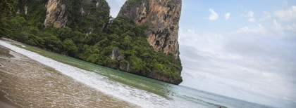 Ein schöner Sandstrand mit großen Felsen im Hintergrund
