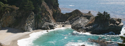 Eine weißer Sandstrand in einer kleinen Bucht an der kalifornischen Küste