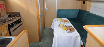 Innenraum eines Bootes mit einer Küche, Esstisch und einem Sofa